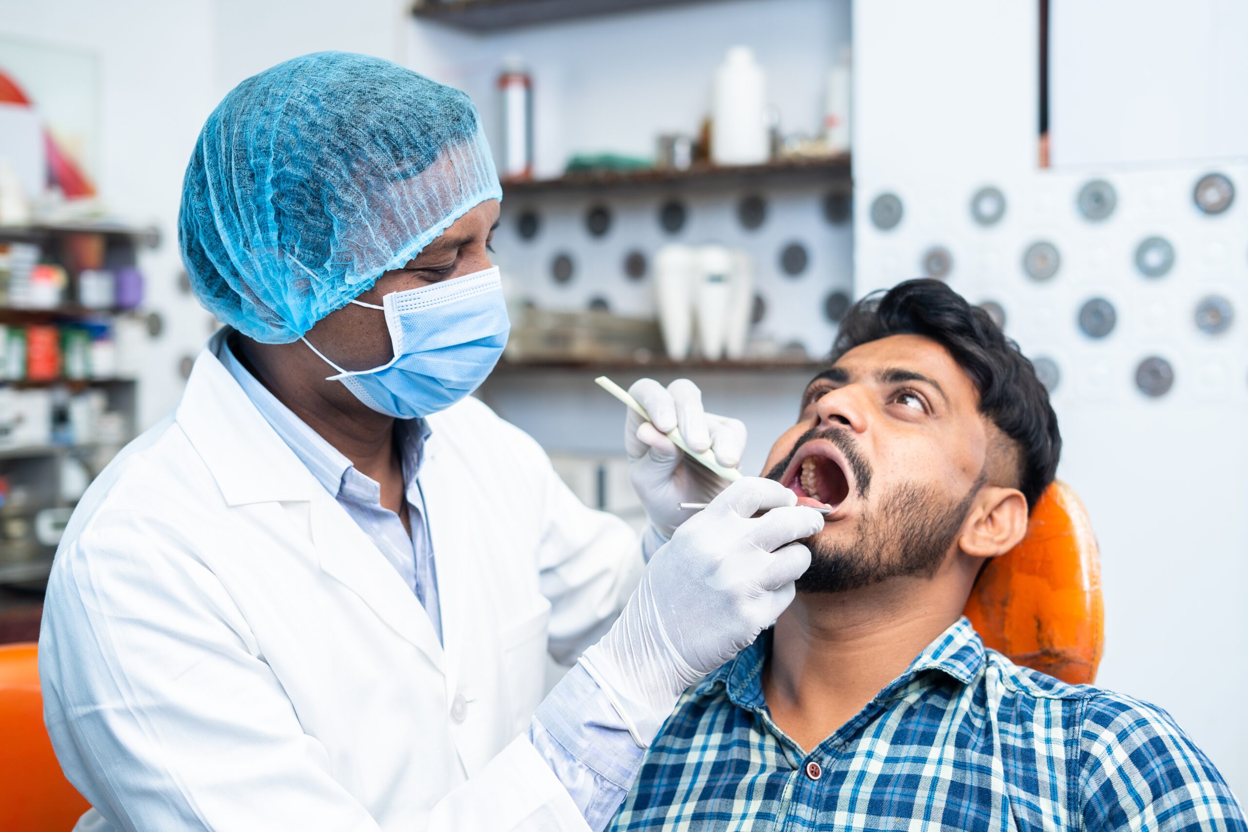 Dentist,With,Surgical,Gloves,And,Face,Mask,Checking,Teeth,Of