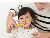 Child toothbrushing from behind - shutterstock